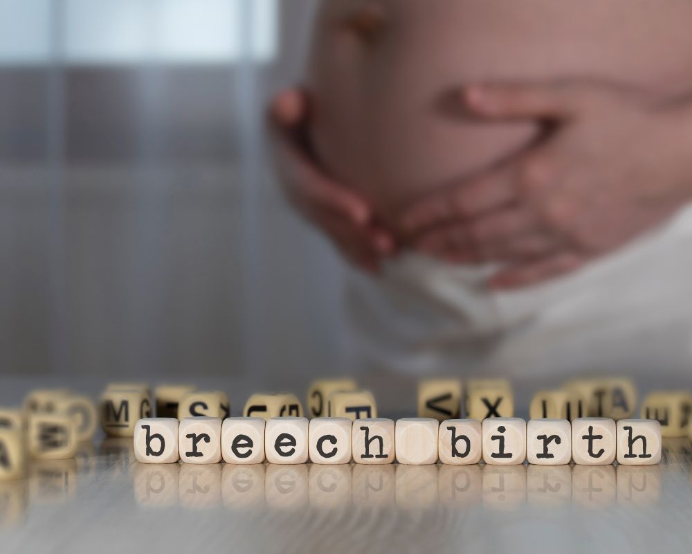 zdjęcie przedstawia ciążowy brzuc na drugim planie oraz napis breech birth na pierwszym planie.